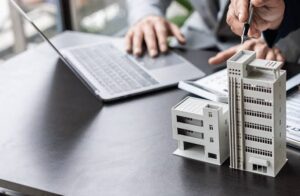 Inicio Maquetas de edificios junto a una laptop en una oficina inmobiliaria